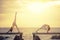 two woman playing yoga pose on wooden pier against sun rising over sea beach