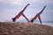 Two woman posing yoga on sea beach