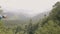 Two woman standing on mountain peak and looking on green hills and forest