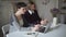 Two woman students sitting at table and using notebook for online education