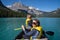 Two woman use paddle oars while canoeing on Emerald Lake in the Canadian Rockies