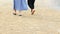 Two woman walking on sand beach