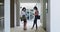 Two woman wearing face masks greeting each other by touching feet at office