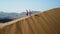 Two woman winner traveler standing sand desert dune mountain ridge valley landscape aerial view