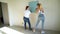 Two woman workers using roller to paint the walls in the apartment or house. Construction, repair and renovation.