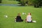 Two womans with dogs rest in the park