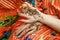 Two womans hands mehendi picture orange bright fabric with pleats
