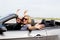 Two women with arms up in convertible