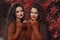 Two Women autumn outdoor portrait. Young beautiful brunette twin