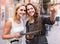 Two women with baggage checking route outdoors