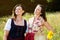 Two women in bavarian dirndl standing outdoors and enjoying the sun