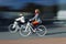 Two women on the blurred bikes in profile