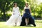 Two women brides with wedding dress back and white walking in a park