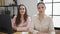 Two women business workers sitting on table with relaxed expression at office