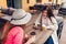 Two women chatting while having coffe in outdoor cafe. Happy friends using phone checking pictures. Girls hang out