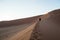 Two Women Climbing Big Daddy Dune during Sunrise, Desert