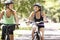 Two Women Cycling Through Park