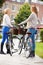 Two Women Cycling Through Urban Park Together