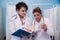 Two women doctors look at patient tests,looking through some patients medical papers