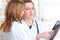 Two women doctors looking on tablet