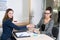 Two women doing a handshake during a meeting