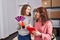 Two women ecommerce business workers using touchpad choosing color at office