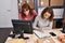 Two women ecommerce business workers writing on document at office