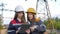 Two women energy workers conducts an inspection of equipment and power lines