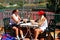 Two women enjoying a cold drink after a game of tennis in the sun