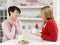 Two Women Enjoying Hot Drink In Kitchen