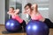 Two women in a fitness center on a Fitness Ball