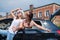 Two women are fooling around at the car. Girlfriends travel by car