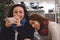 Two women friends enjoying a joke and a chat and a cup of coffee or tea, laughing and smiling in a cafe