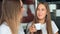 Two women friends in a kitchen drinking coffee, talking and having fun