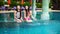 Two women friends splashing water in swimming pool