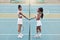 Two women handshake after tennis match. Young friends greet each other before tennis practice. African american athletes