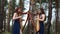 Two women harpists stand at forest  and play harps .