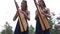 Two women harpists stand and play harps. Closeup.