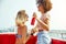 Two women having fun on a boat during their vacation