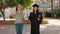 Two women mother and graduated daughter jumping at park