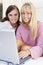 Two women on patio using laptop