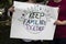 Two women at protest holding homemade sign together that says keep families together with world and families holding hands on it