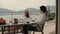 Two women relax at table with food on terrace Rbbro. vacation, sitting on balcony terrace in hotel