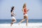 Two women running along beach