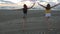 Two women running towards the sea on the beach