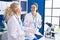 Two women scientists smiling confident speaking at laboratory