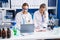 Two women scientists talking on the smartphone working at laboratory