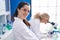 Two women scientists using microscope working at laboratory