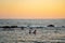 Two women sharing paddle board at sunset on calm waters in mediterranean sea in cyprus. Two girls on paddling on SUP