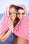 Two Women Sheltering From Sun On Beach Holiday